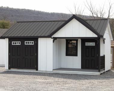 Custom 12x20 Victorian Building with Porch and with White LP Board N Batten Siding, Black Doors, Black Trim, and Black Metal Roof